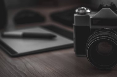 Ev ofis iç fotoğrafçı masa natürmort. Profesyonel fotoğraf medya çalışma donanımları, kamera gövdesi, lensler, monitör ve tablet