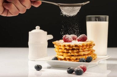 Ahududu ve eleme pudra şekeri ve Ballı süt beyaz bir tablo şişe ile servis Belçika waffle