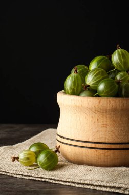 Bektaşi üzümü siyah yüzeyinde küçük bir ahşap tencerede sulu olgun çilek. Bektaşi üzümü hasat