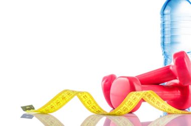 Fitnes sembolleri - kırmızı dambıl, bir şişe su ve havlu. Sağlıklı bir yaşam tarzı kavramı