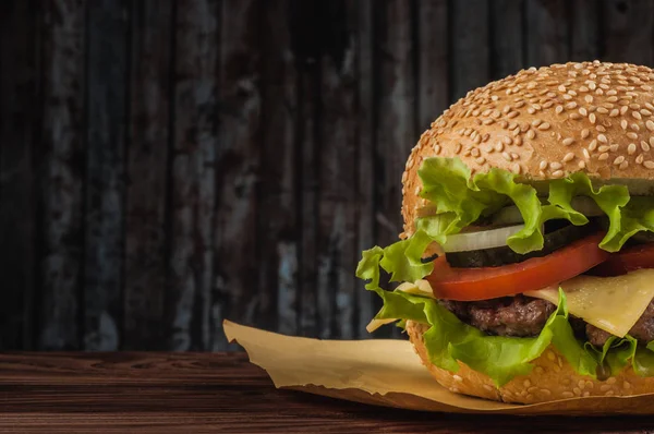 Вкусный чизбургер с ингредиентами салата на жареной говяжьей котлетке на деревенском деревянном столе с копирайтом — стоковое фото