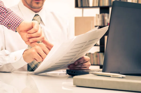 Lagarbete process, affärsmän händerna pekar på laptop och dokument under förklaring av nya plan projektdata vid möte. — Stockfoto