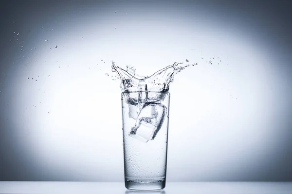 Salpicadura de agua en vasos aislados en blanco — Foto de Stock