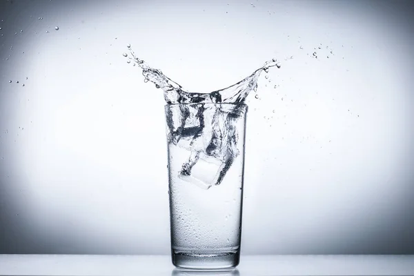 Salpicadura de agua en vasos aislados en blanco — Foto de Stock