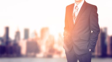 Bulanık şehir arka plan üzerinde iş adamı. Güneş ışığı etkisi