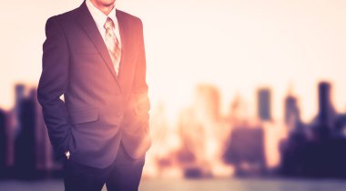 Bulanık şehir arka plan üzerinde iş adamı. Güneş ışığı etkisi