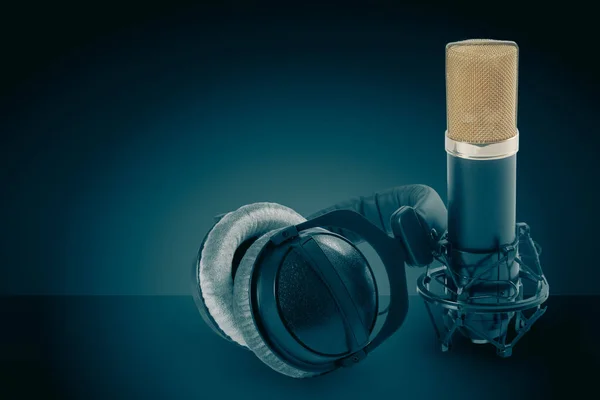 Casques et microphone à condensateur sur fond sombre — Photo