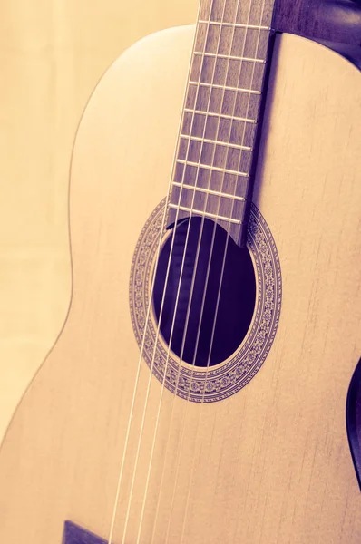Parte de una guitarra acústica sobre un fondo gris . — Foto de Stock