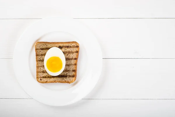 Vista superior de torrada de sanduíche saudável e metade de ovo em um fundo de madeira — Fotografia de Stock