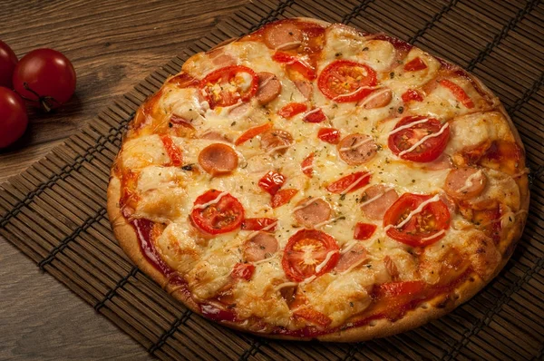 Горячая пицца с плавильным сыром на деревенском деревянном столе Стоковое Фото