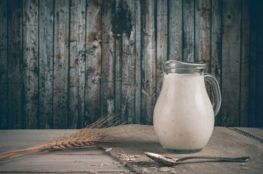 Taze süt ürünleri ve buğday rustik ahşap zemin üzerine.