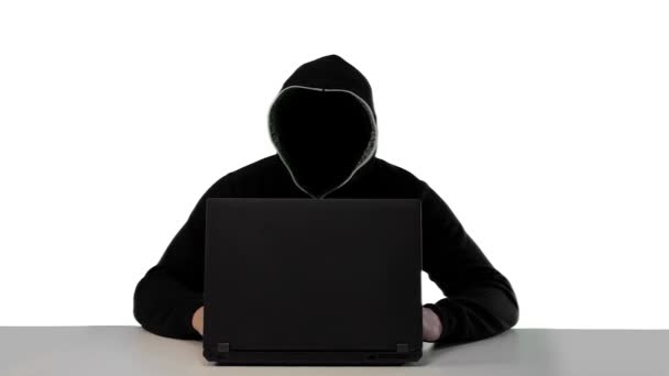 Анонимный хакер в черном капюшоне с ноутбуком — стоковое видео