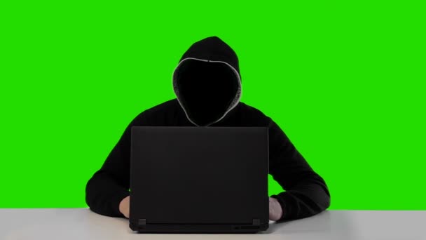 Anonymous hacker v černé kápi s přenosným počítačem — Stock video