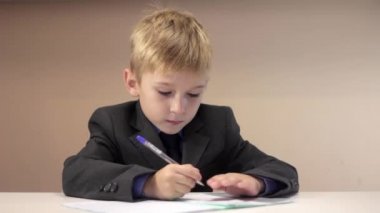 Ciddi çocuk onun defter üzerinde yazma