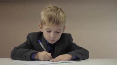 Ciddi çocuk onun defter üzerinde yazma