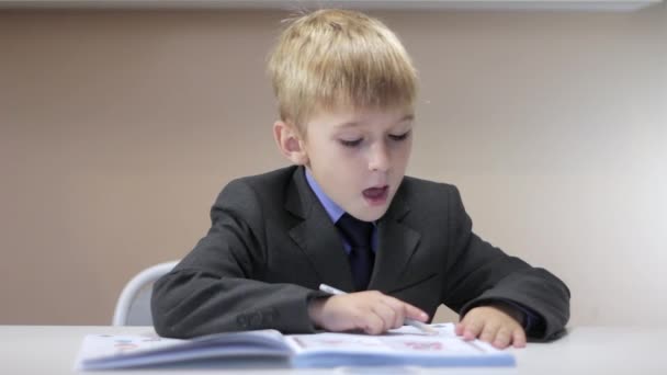 Serious boy writing on his notebook and funny dance — Stock Video