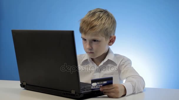 Schattige kleine jongen laptop en creditcard gebruiken — Stockvideo