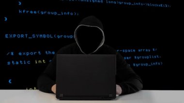 Bir dizüstü bilgisayar ile siyah başlıklı hacker