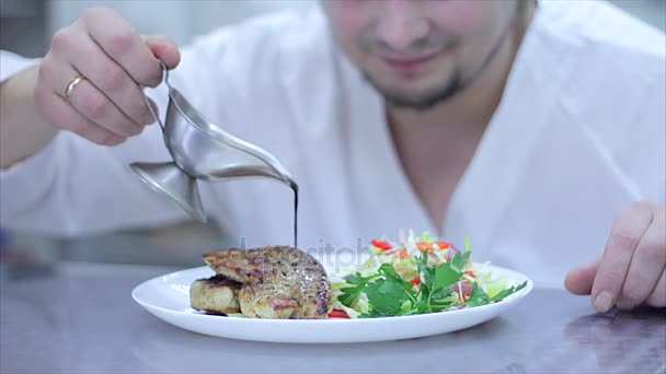 A delicious gourmet meal is being given the finishing touches by the chef in a restaurant or hotel kitchen, ready for service to the customer. Slow motion — Stock Video