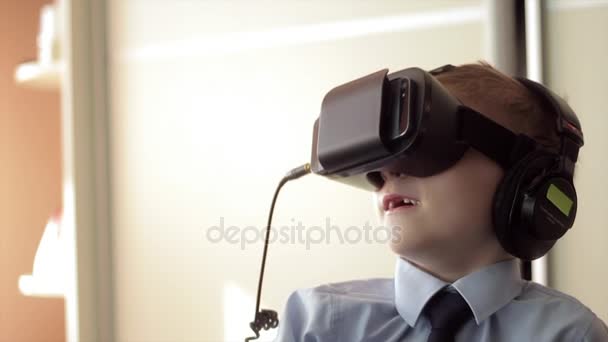 Маленький мальчик использовать шлем гарнитуры виртуальной реальности, он очень впечатлен — стоковое видео