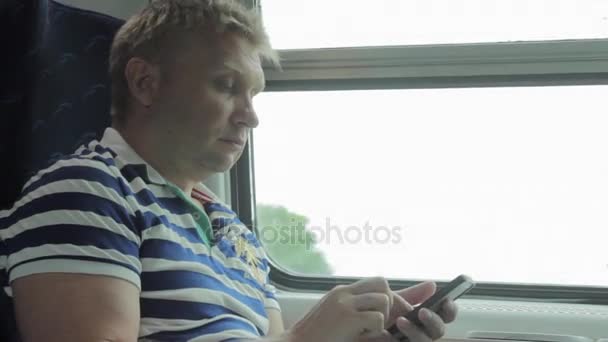 Hombre usando el teléfono inteligente en un tren — Vídeo de stock