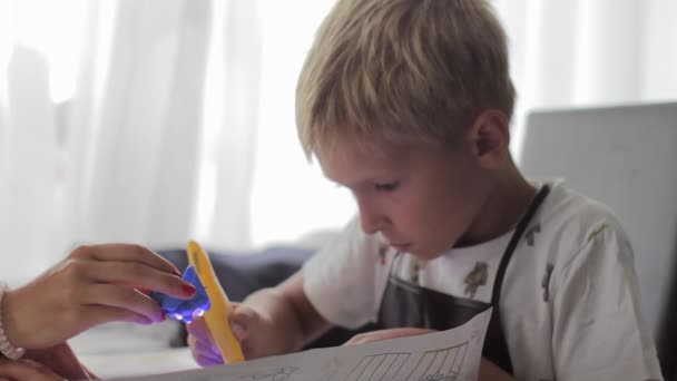 Moeder helpt zijn zoon om zijn huiswerk te doen — Stockvideo