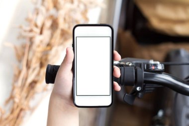 Oğlanın elini kullanma smartphone yakınındaki Bisikletleri ile karayoluyla durduğunu iken