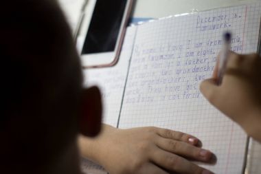 Yakın çekim çocuk el ile İngilizce kelime el ile geleneksel beyaz not defteri kağıda yazı kalem.