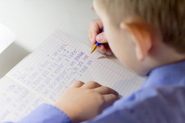 Yakın çekim çocuk el ile İngilizce kelime el ile geleneksel beyaz not defteri kağıda yazı kalem.