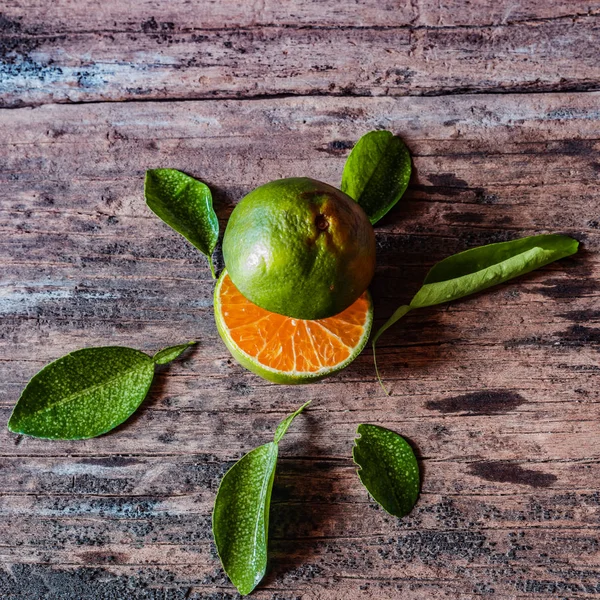 Köy ahşap masasında yaprakları olan bir dilim taze yerel portakal. Endonezya 'da bu meyveye jeruk denir..