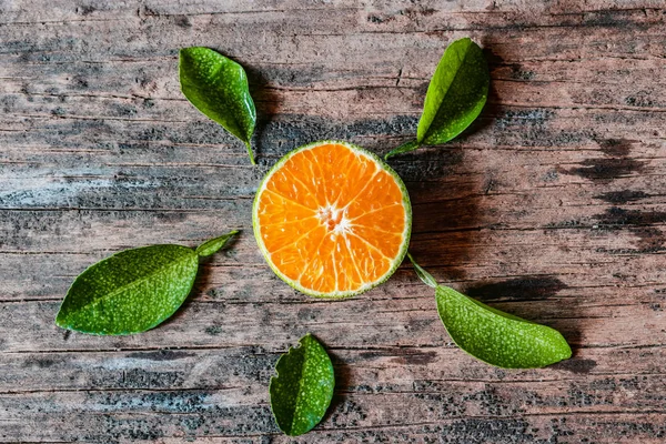 Köy ahşap masasında yaprakları olan bir dilim taze yerel portakal. Endonezya 'da bu meyveye jeruk denir..