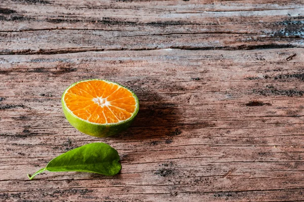 Köy ahşap masasında yaprakları olan bir dilim taze yerel portakal. Endonezya 'da bu meyveye jeruk denir..