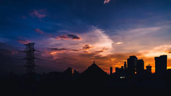 Dramatik gün batımı gökyüzü ve binalar silueti