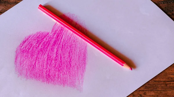 Heart symbol on white paper created from pink pencil