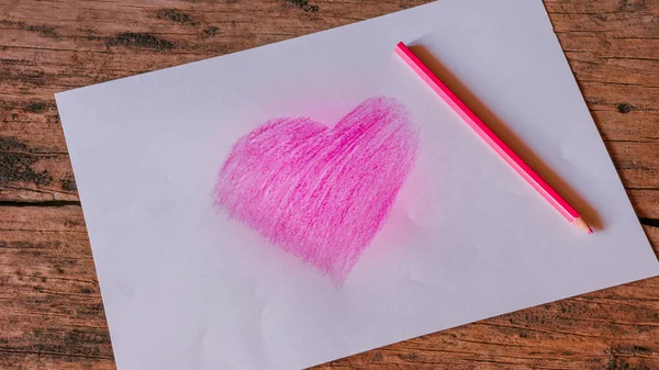 Heart symbol on white paper created from pink pencil