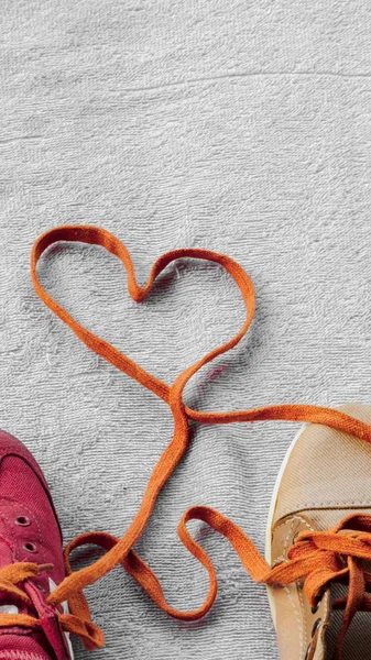 Shoelaces that unite a pair of sneakers are formed into a heart 