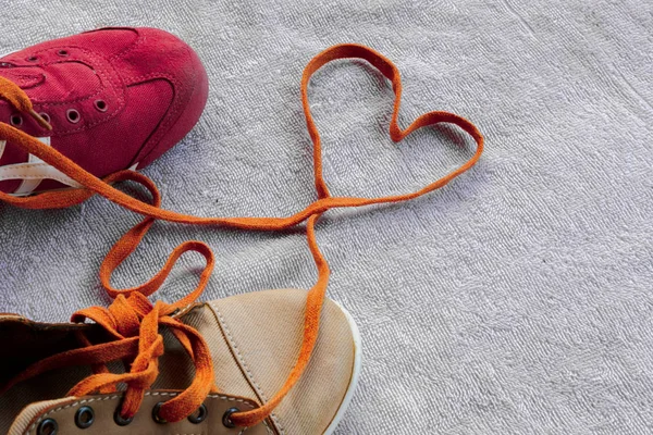 Shoelaces that unite a pair of sneakers are formed into a heart 