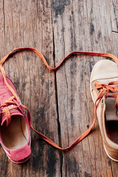 Shoelaces that unite a pair of sneakers are formed into a heart 