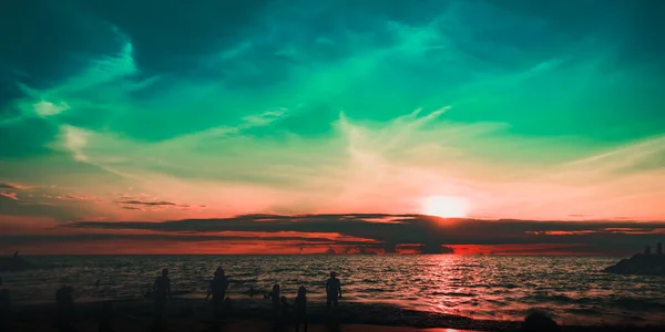 Dramatik gökyüzü ve bulutlar. Çocuklarıyla şehir sakinleri deniz kenarında bir hafta sonunun tadını çıkarıyorlar.. 