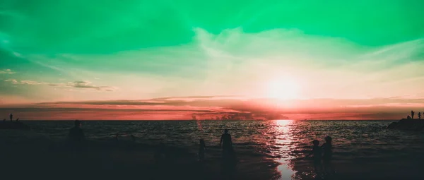 Dramatik gökyüzü ve bulutlar. Çocuklarıyla şehir sakinleri deniz kenarında bir hafta sonunun tadını çıkarıyorlar.. 