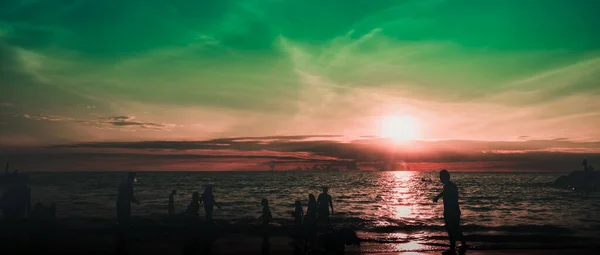 Dramatik gökyüzü ve bulutlar. Çocuklarıyla şehir sakinleri deniz kenarında bir hafta sonunun tadını çıkarıyorlar.. 