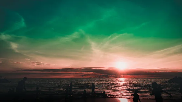 Dramatik gökyüzü ve bulutlar. Çocuklarıyla şehir sakinleri deniz kenarında bir hafta sonunun tadını çıkarıyorlar.. 