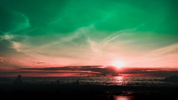 Dramatik gökyüzü ve bulutlar. Çocuklarıyla şehir sakinleri deniz kenarında bir hafta sonunun tadını çıkarıyorlar.. 