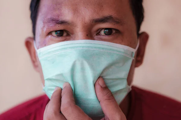 Endonezyalı adam kendini covid-19 salgınından korumak için tıbbi maske takıyor.