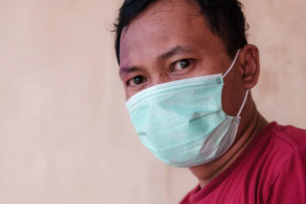 Asian man wears a health mask to anticipate the spread of diseases caused by viruses, such as coronavirus or covid-19 and avian influenza, which can become a world pandemic. Illustration of Coronavirus pendemic 2020