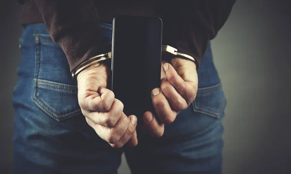 Man hand handcuffs and phone — Stock Photo, Image