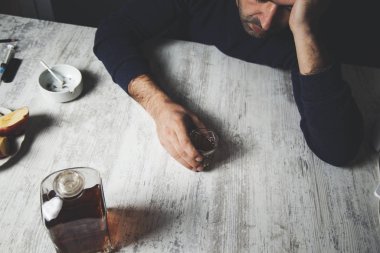 Üzgün adam elinde sigarayla viski