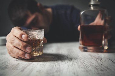 Adam elinde cam olan viski şişesi.