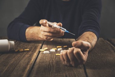 Ahşap masanın üzerinde uyuşturucu bulunan bir şırınga.