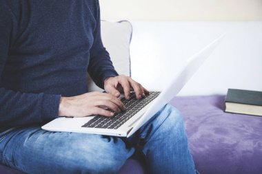 Genç adam beyaz defterini kanepeye uzattı.